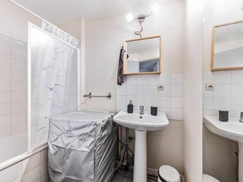 een witte badkamer met een wastafel en een douche bij Le Saboly in Avignon