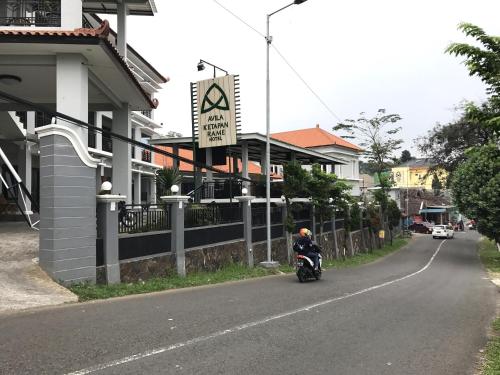 a person riding a motorcycle down a street at Avila Ketapan Rame Hotel in Trawas