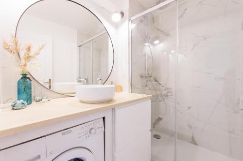 une salle de bain blanche avec un lavabo et une douche dans l'établissement Appartement avec jardin, clim & piscine - Proche plages et randos, parking privé - La Girelle, à Hyères
