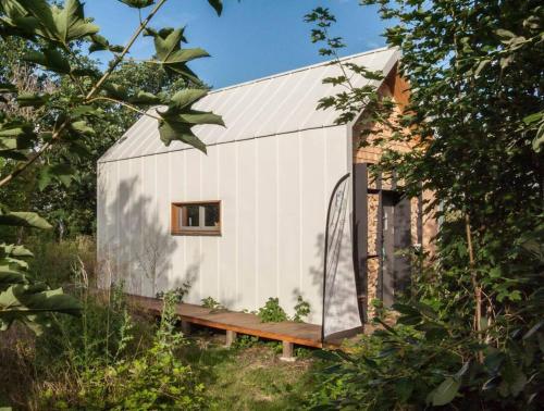 Una casa blanca con una ventana en el costado. en Tiny Haus auf idyllischem Grundstück im Rittergut, en Klipphausen
