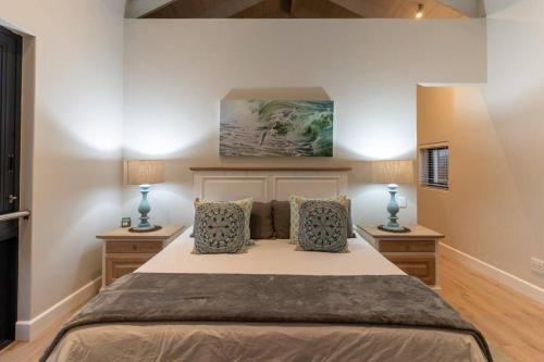 a bedroom with a large bed with two night stands at Hermanus Beach House at CShine in Hermanus