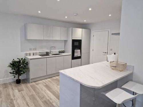 a kitchen with white cabinets and a white counter top at Luxury 3 Bed House, Parking, Garden and 2 Office desks 2 in Southbourne