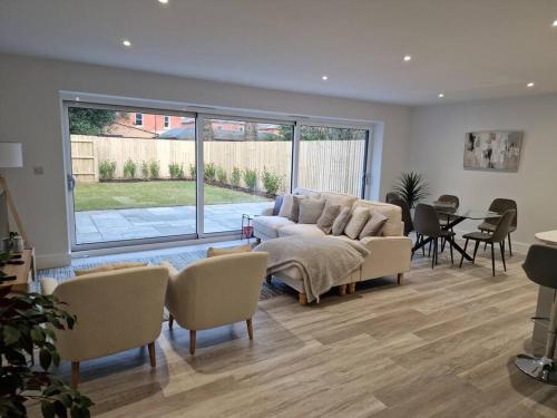 a living room with a couch and a table and chairs at Luxury 3 Bed House, Parking, Garden and 2 Office desks 2 in Southbourne