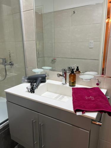 uma casa de banho com um lavatório e um espelho em Departamento Torre Duomo Nueva Cordoba em Córdoba