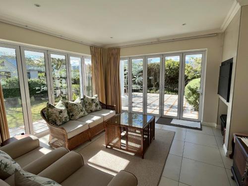a living room with couches and a tv and windows at Kingswood Close in George