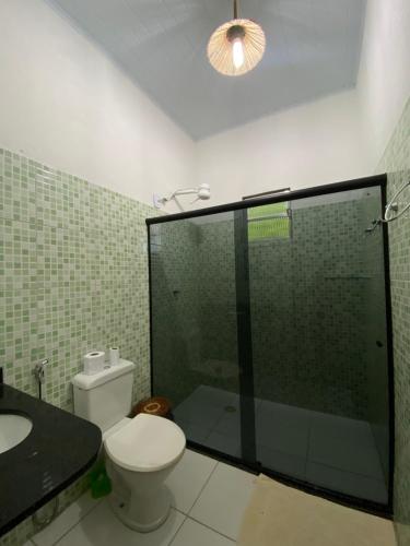 a bathroom with a toilet and a glass shower at Terra Hostel e Pousada in Lençóis
