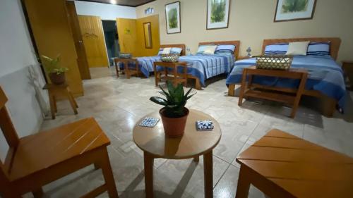a bedroom with two beds and a table and chairs at Poseidon Guest House in Iquitos