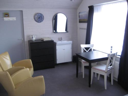 a dining room with a table and chairs and a sink at Bed and Breakfast De Mozaiektegel Uden in Uden