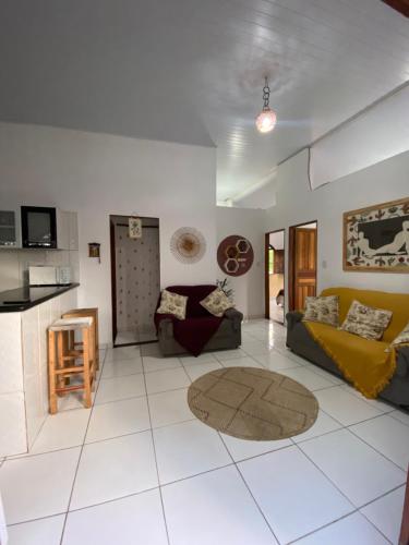 a living room with two couches and a kitchen at Terra Hostel e Pousada in Lençóis