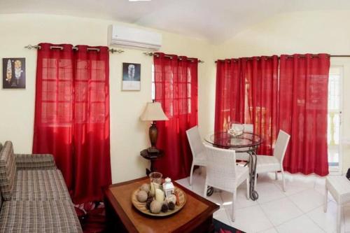uma sala de estar com cortinas vermelhas e uma mesa em Apartamento en la Romana em La Romana