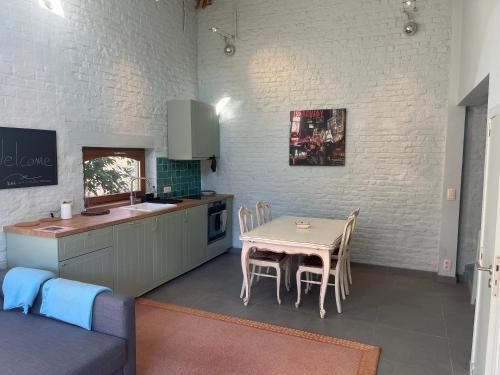 cocina y comedor con mesa y sillas en Cosy little house, en Kraainem