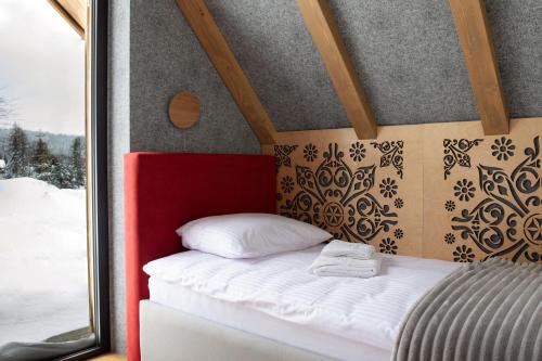 a bed in a small room with a window at Leśny Wierch luxury spa villas in Bukowina Tatrzańska
