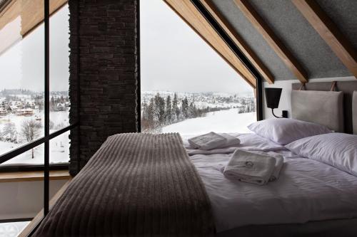 łóżko w pokoju z dużym oknem w obiekcie Leśny Wierch w Bukowinie Tatrzańskiej