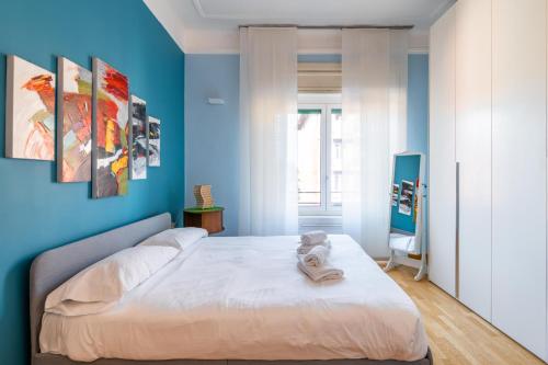 a blue bedroom with a bed with towels on it at Easylife - Spazioso e accogliente bilocale in zona Lambrate in Milan