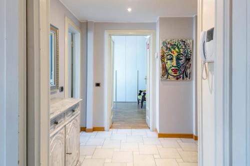 a hallway with a painting of a face on the wall at Easylife - Spazioso e accogliente bilocale in zona Lambrate in Milan