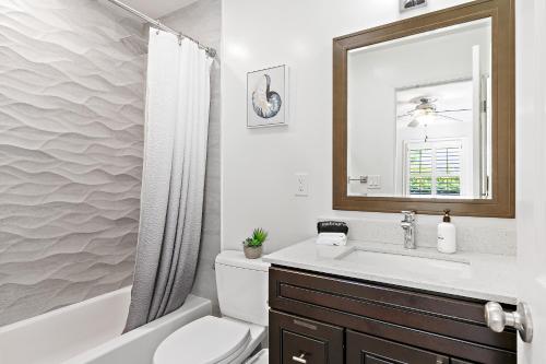 a bathroom with a sink and a toilet and a mirror at @ Marbella Lane - Modern Refreshing Home in San Mateo
