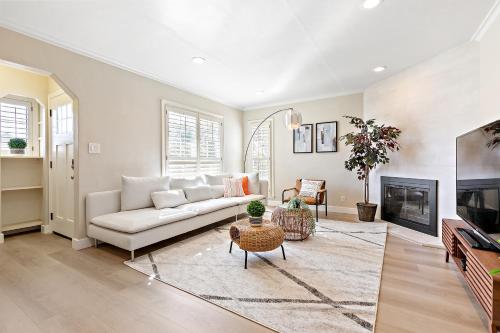 a living room with a white couch and a fireplace at @ Marbella Lane - Modern Refreshing Home in San Mateo