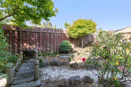a garden with a fence and a wooden walkway at @ Marbella Lane - Modern Refreshing Home in San Mateo