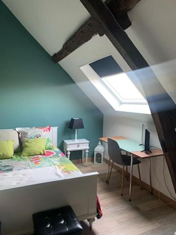 a bedroom with a bed and a desk with a computer at La Bretonnière, Longère Picarde in Passel