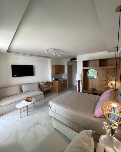 a large bedroom with a bed and a couch at Wide Blue Luxury Boutique Suites in Neos Marmaras