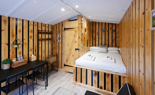 een slaapkamer met een bed in een houten muur bij Woodshed Pod in Fort William