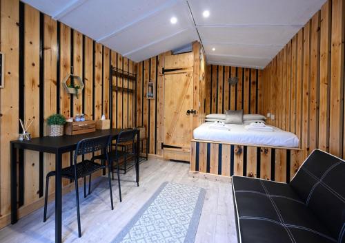 a bedroom with a bed and a table and chairs at Woodshed Pod in Fort William