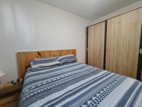 uma cama com lençóis azuis e brancos em Apartamento B&F em Costa de Antigua
