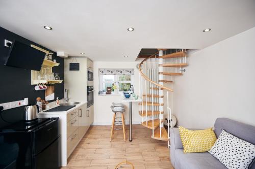 uma cozinha e uma sala de estar com uma escada em espiral em Carreglwyd em Llandeilo