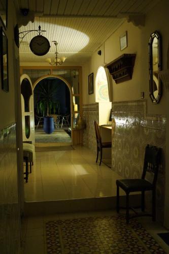 a living room with a table and chairs and an open door at Dar Omar Khayam in Tangier