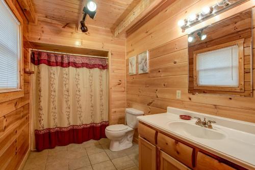 La salle de bains est pourvue de toilettes et d'un lavabo. dans l'établissement Take It Easy, 3 Bedrooms, Pool Table, Foosball, Hot Tub, WiFi, Sleeps 12, à Pigeon Forge