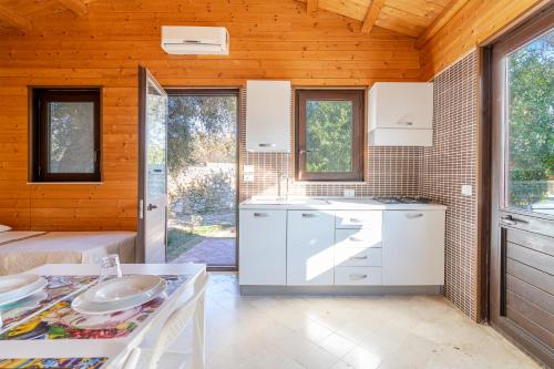 a kitchen with white cabinets and a table at Agriturismo Kypeiros in Noto