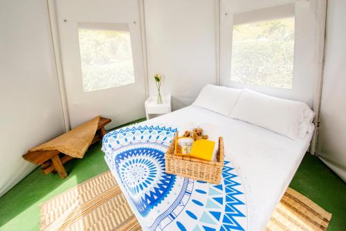 a small bedroom with a bed with a basket on it at Cerro Tusa Glamping in Titiribí