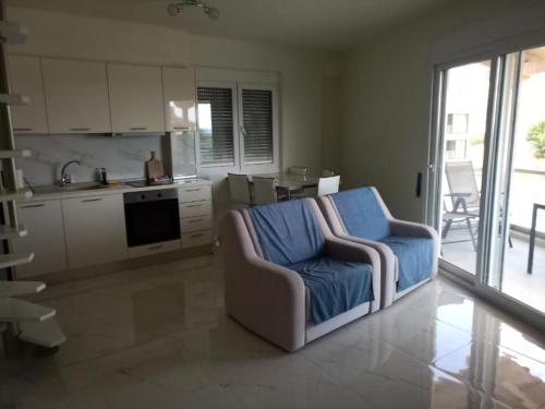 a living room with a chair and a kitchen at Villa K View Nikiti in Nikiti
