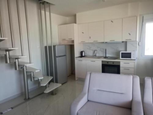 a kitchen with white cabinets and a couch in a room at Villa Nikiti View in Nikiti