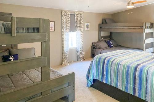 a bedroom with two bunk beds and a bed at Lakefront Retreat with Pier, Bar Hut and Fireplace! in Graford