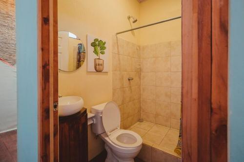 a bathroom with a toilet and a sink and a shower at Habitat Surf Glamp in Santa Teresa Beach