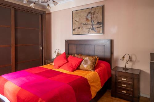 una camera da letto con un grande letto con una coperta colorata di CASA SALMÓN a Cadice