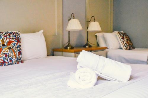 a hotel room with two beds with white sheets and a towel at Gregory by the Warren Collection in Belfast
