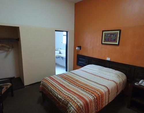 a bedroom with a bed and a bathroom at HOTEL POSADA DE LA MONEDA in Zacatecas