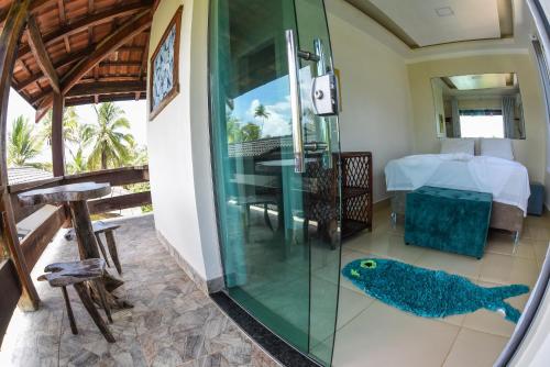 Una ducha de cristal en una habitación con un pez azul en el suelo en João Praia Hotel en Marau