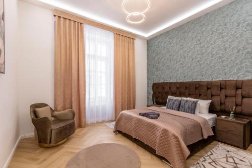 a bedroom with a bed and a chair at Luxurious Bajcsy Residence next to the Basilica in Budapest