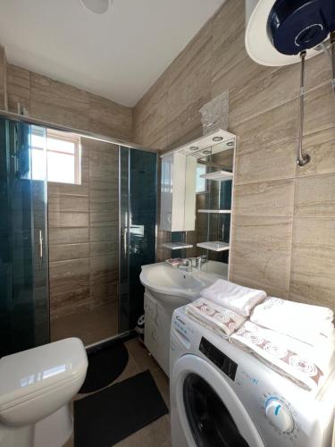 a bathroom with a washer and a washing machine in it at Apartment in Peja city center in Peje