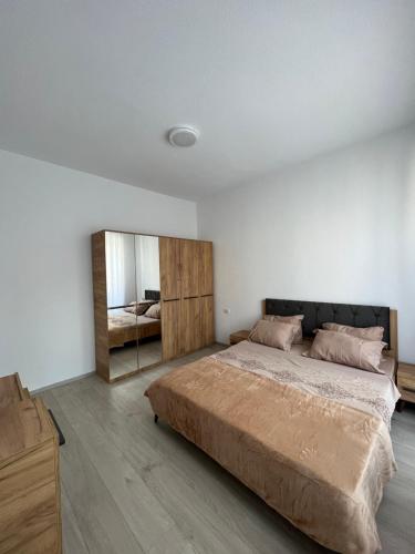 a bedroom with a large bed and a mirror at Apartment in Peja city center in Peje