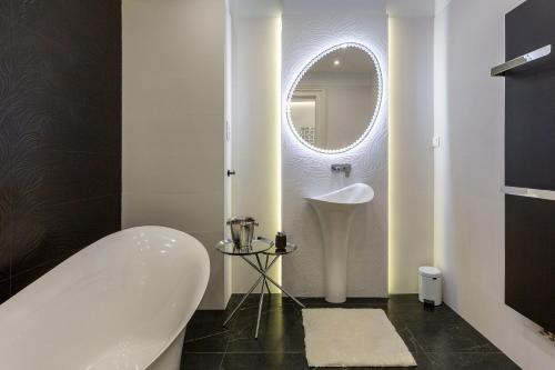 a white bathroom with a sink and a mirror at Luxurious Bajcsy Residence next to the Basilica in Budapest