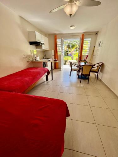 a living room with a red couch and a table at Hôtel DOUCE VAGUE in Sainte-Luce
