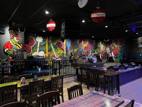 a restaurant with tables and chairs and a stage at Commercial Hotel in Edmonton