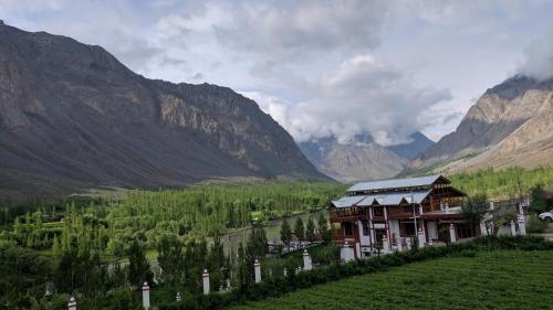 a lodge in a valley with mountains in the background at Ashuna Hotel & Resort in Kargil