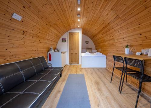 a living room with a couch and a table at Woodside Pod in Fort William