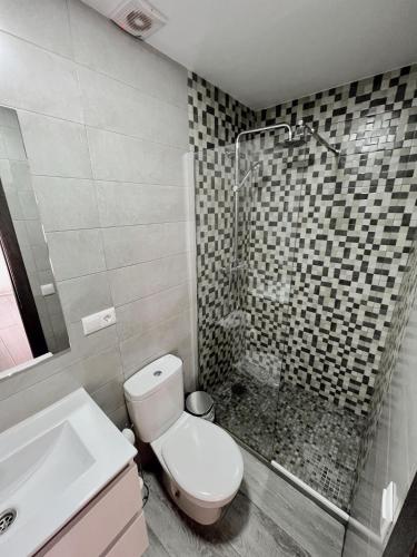 a bathroom with a toilet and a sink and a shower at Apartamentos CEO - Naranja in Ronda