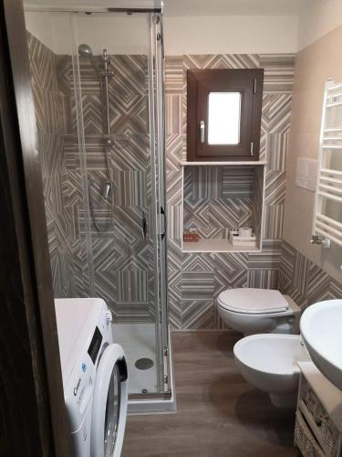 a bathroom with a shower and a toilet and a sink at Lo Stemma Guest House in Melfi